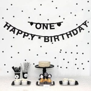 black custom happy birthday banner with star confetti and party tableware