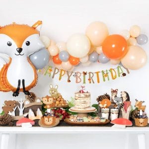 forest animals themed party with animal balloons, happy birthday banner and animal themed cake toppers