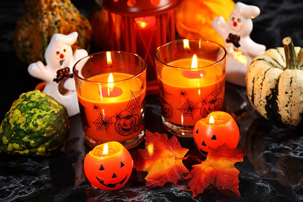 Halloween candle-light with pumpkins on black background