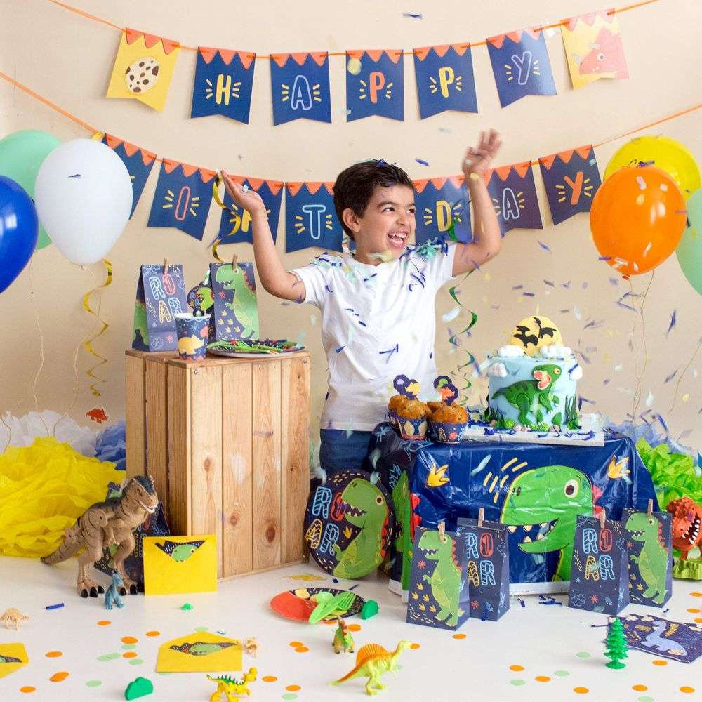 dinosaur themed party decorations with balloons, banner and tableware