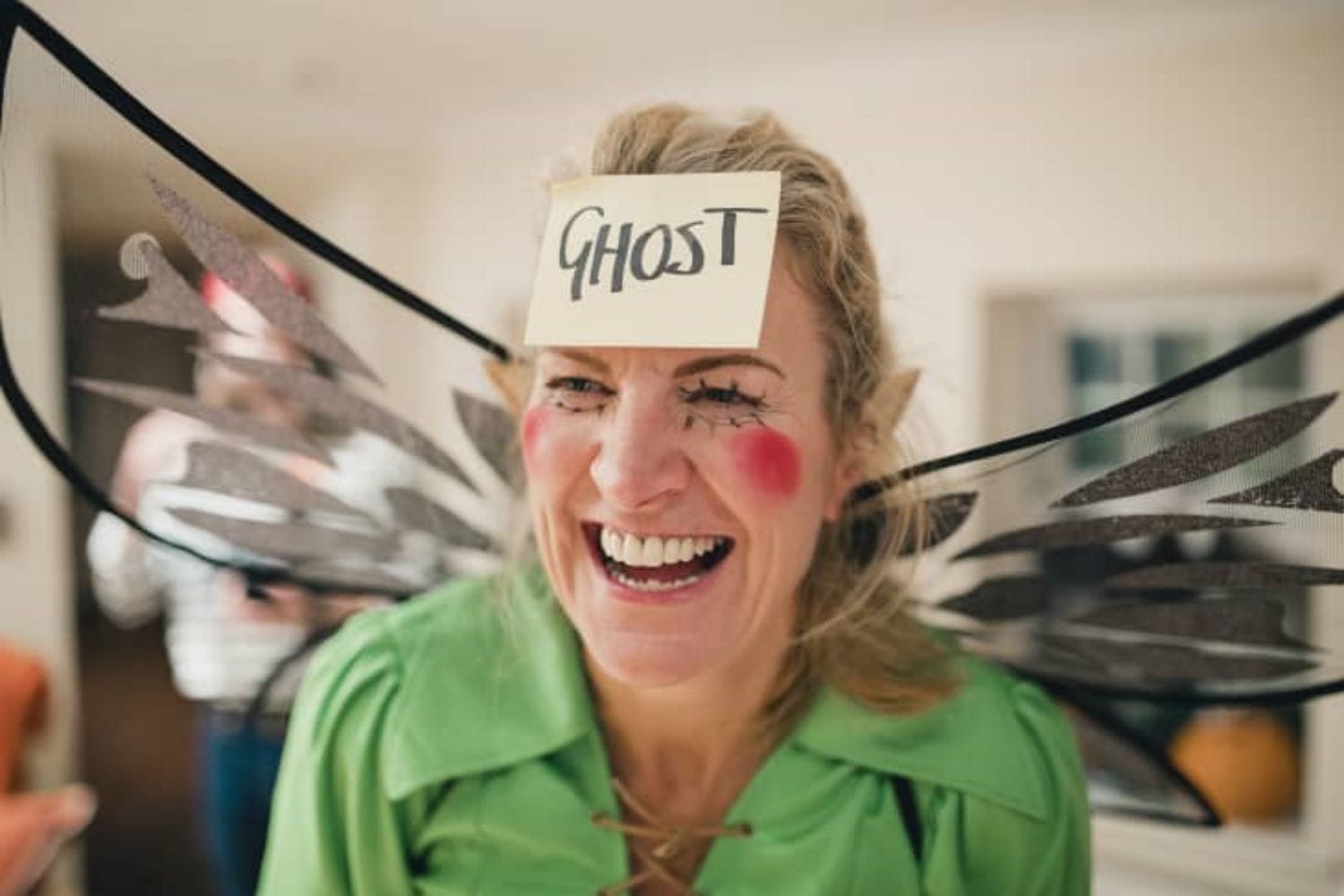 A woman wears a ghost sticker on her forehead Halloween Horror Charades