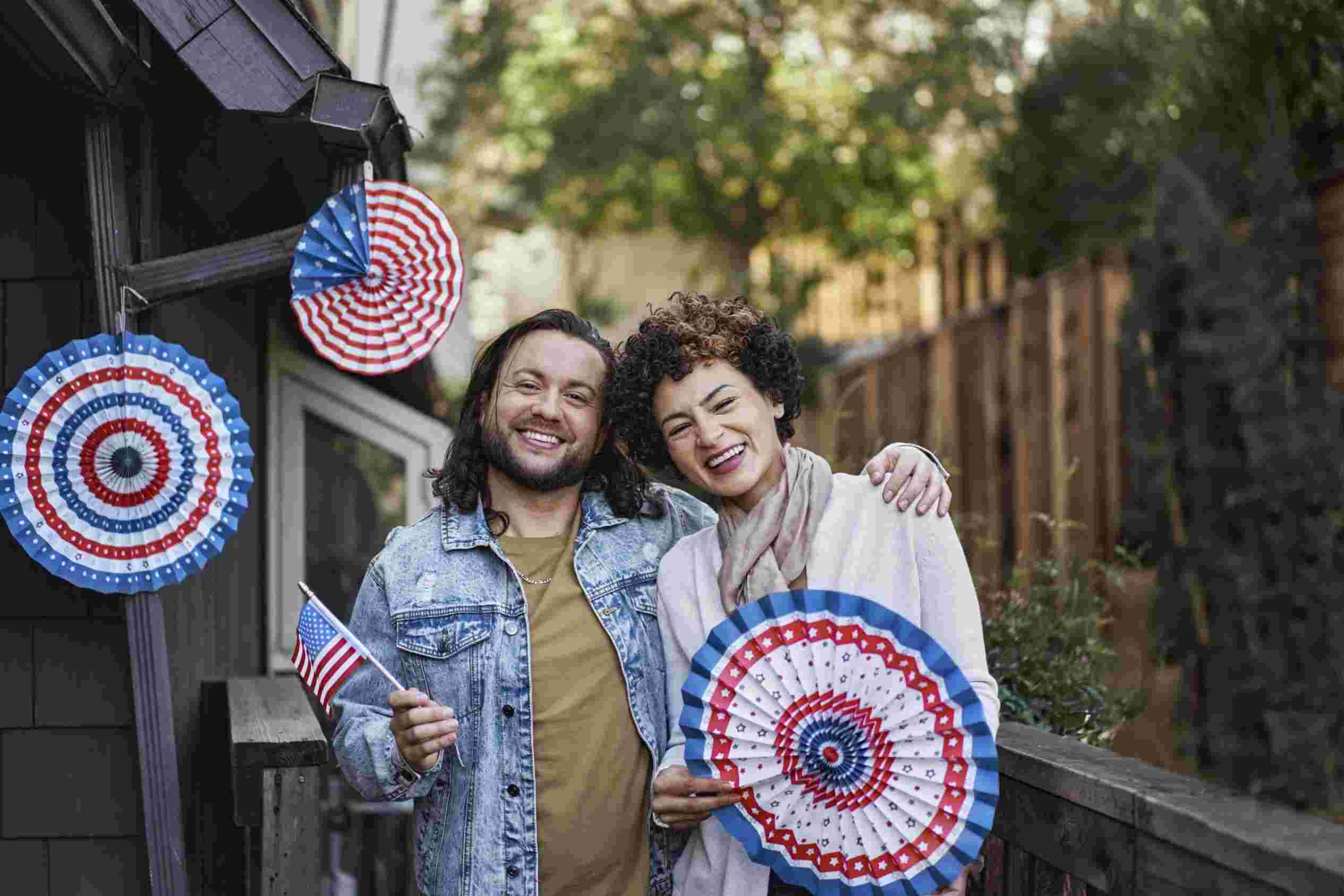 smiley couple with american flag party fans