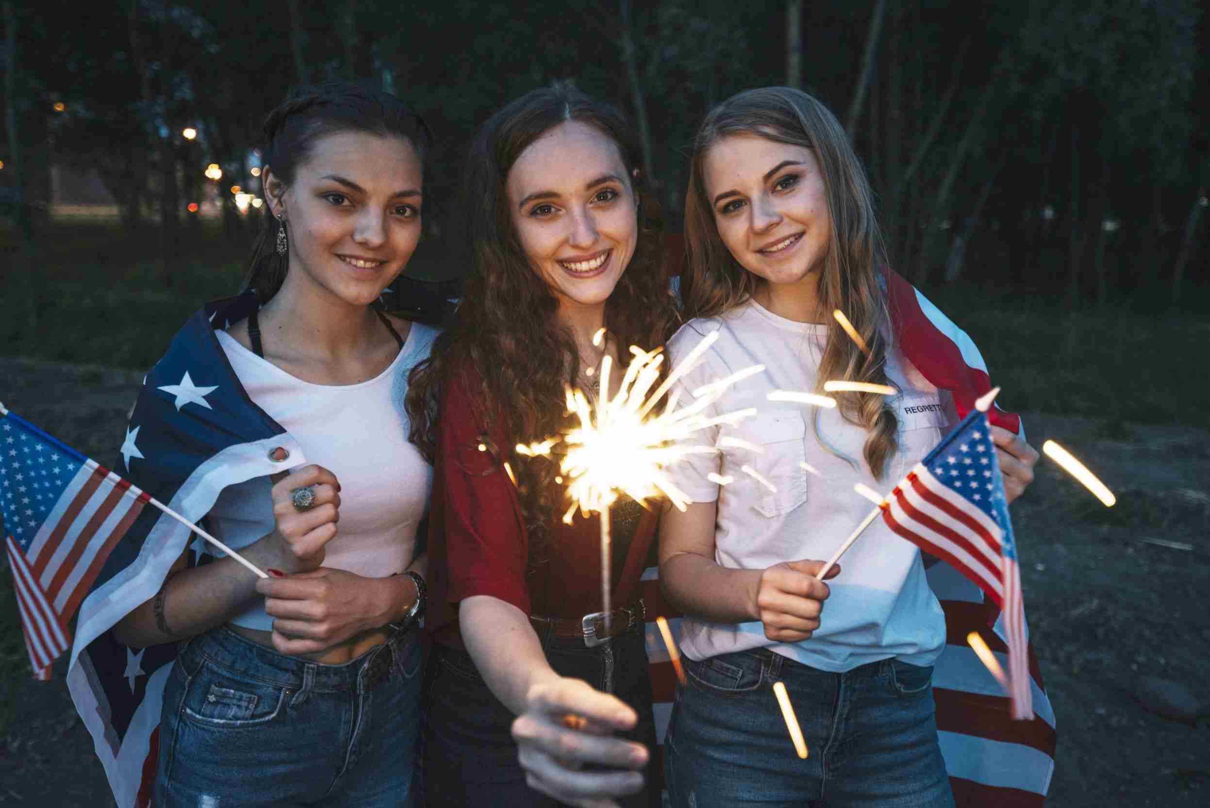 three girls celebrating independence day with sparkler