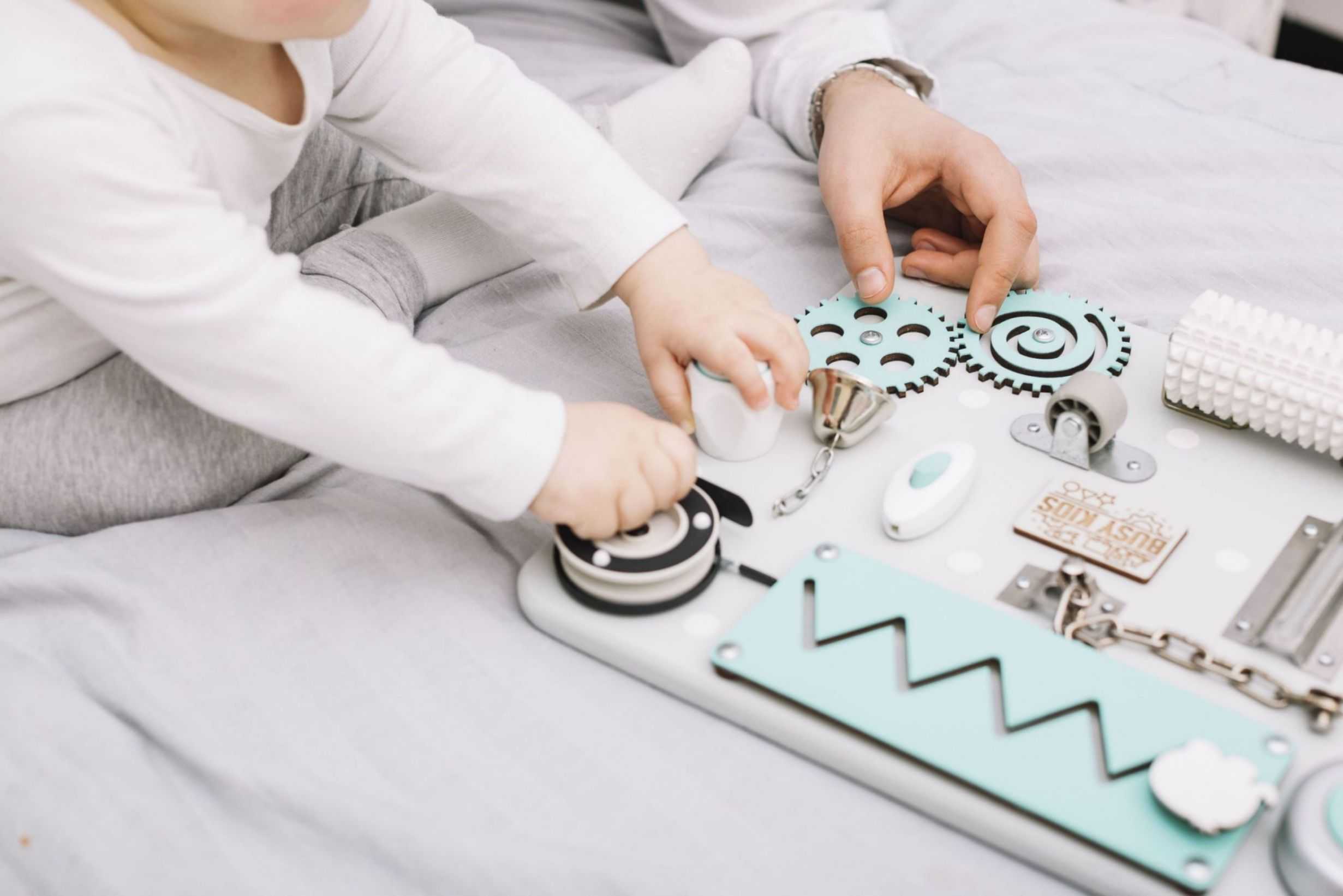 person near little baby with toy sitting bed baby shower ideas