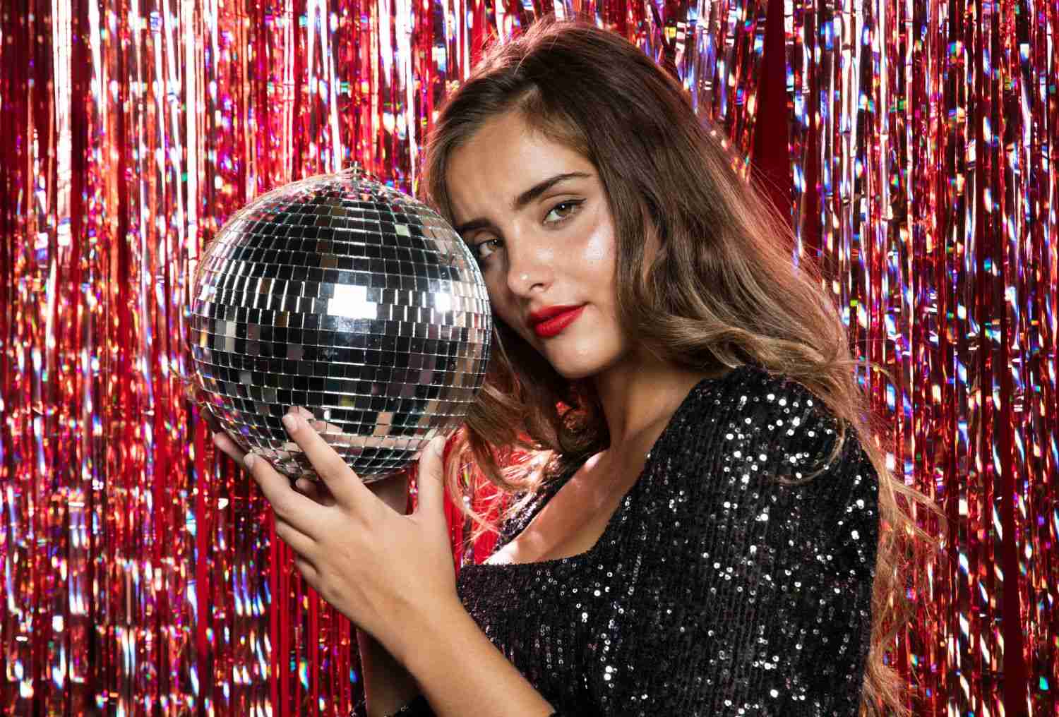 woman standing sideways holding disco ball