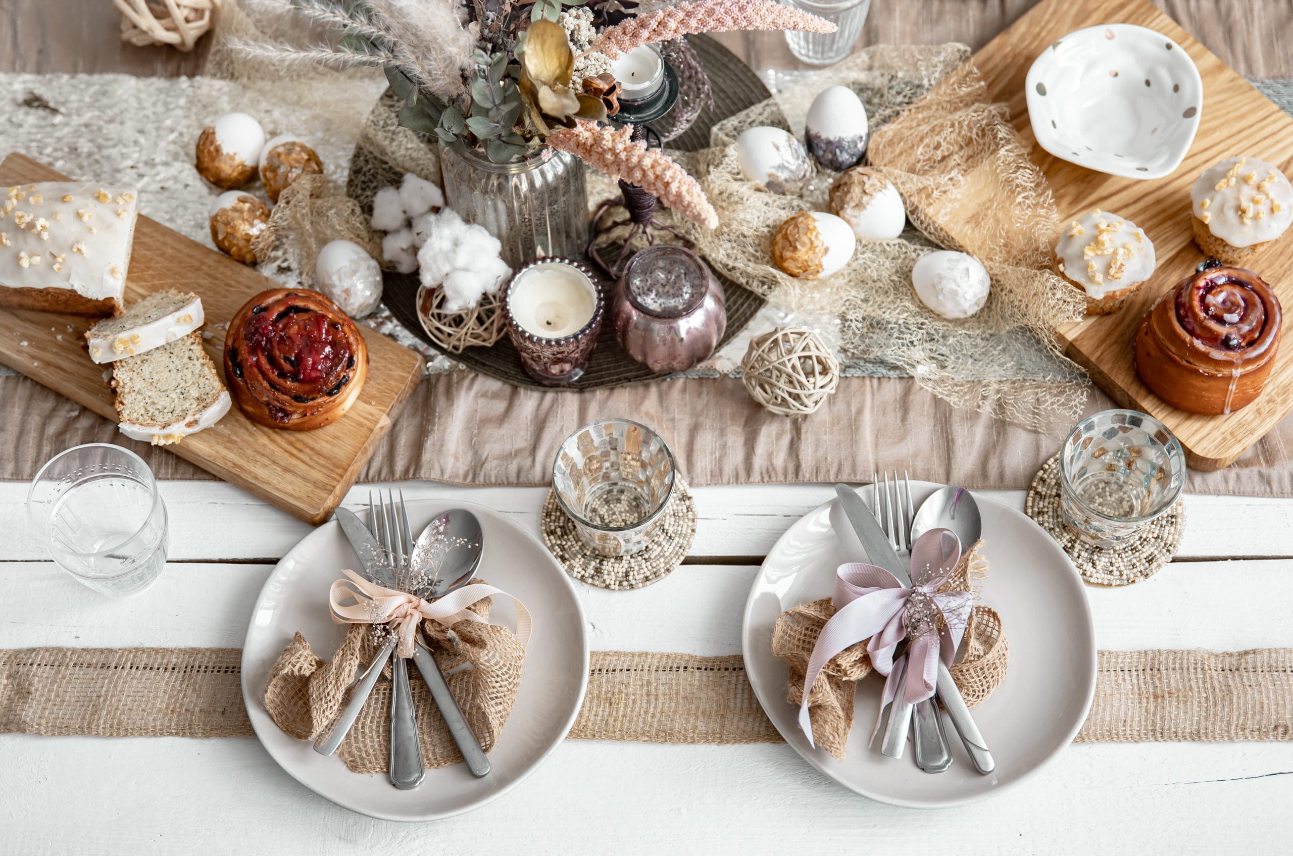 Easter table setting with decor details and homemade cakes top view.