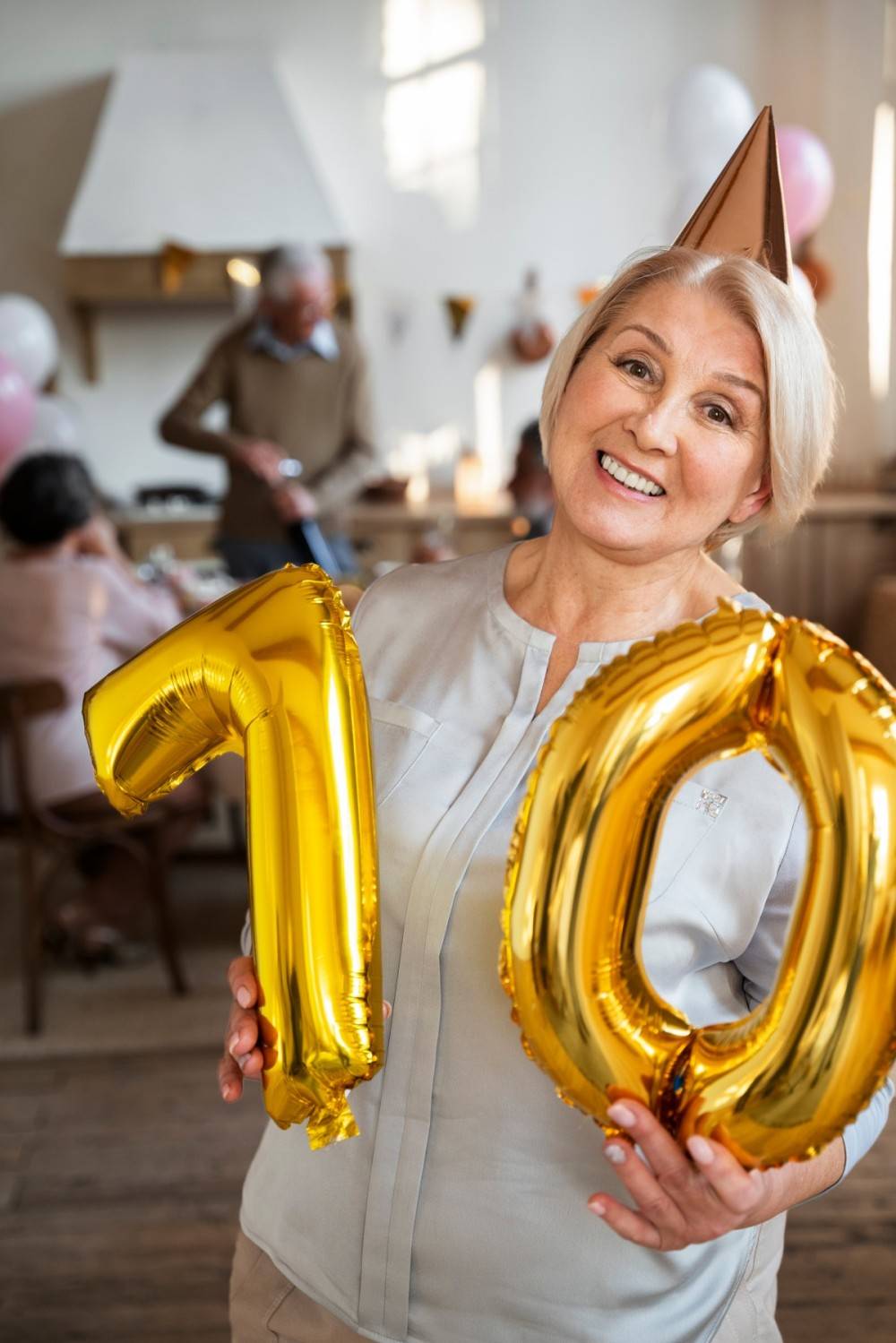 senior person celebrationg with balloons 70th birthday