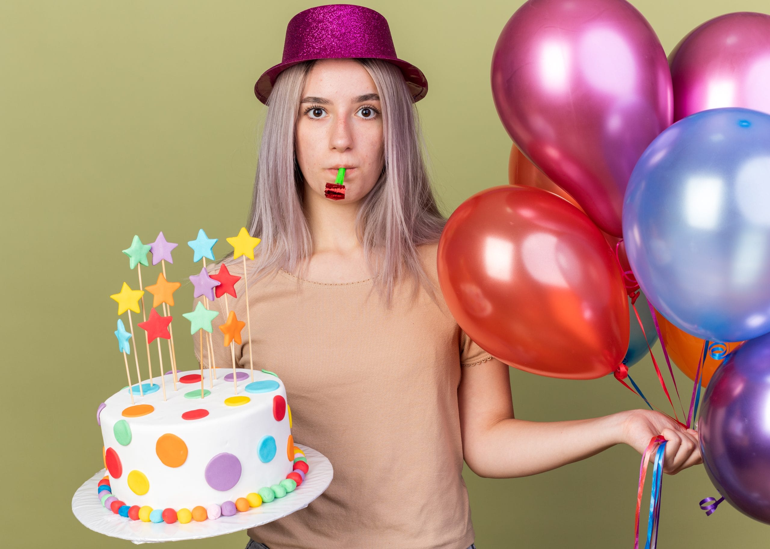 unpleased young beautiful girl wearing party hat holding balloons with cake scaled