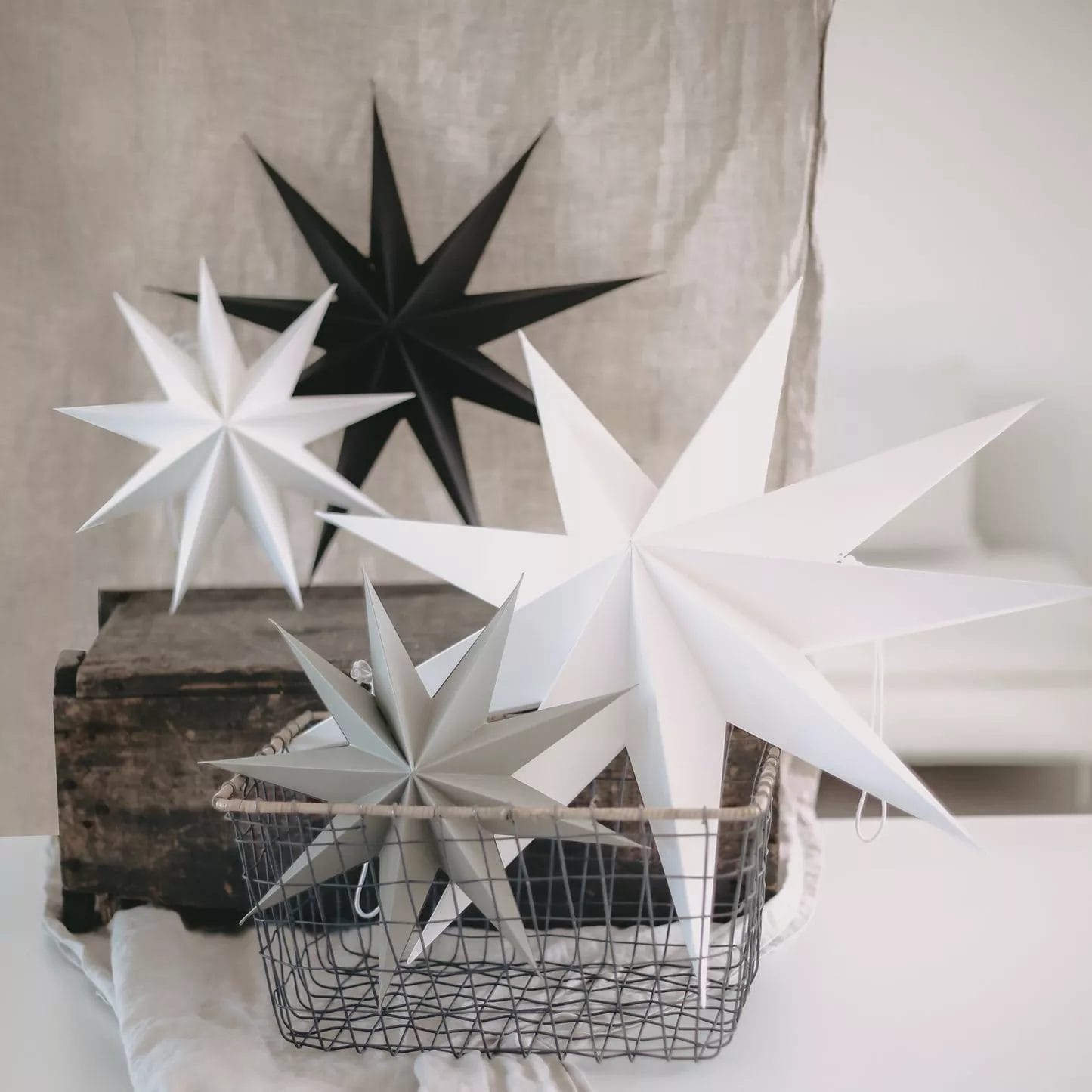 Paper stars in black, white, and gray in a basket minimalist Christmas decoration in Scandinavian style.
