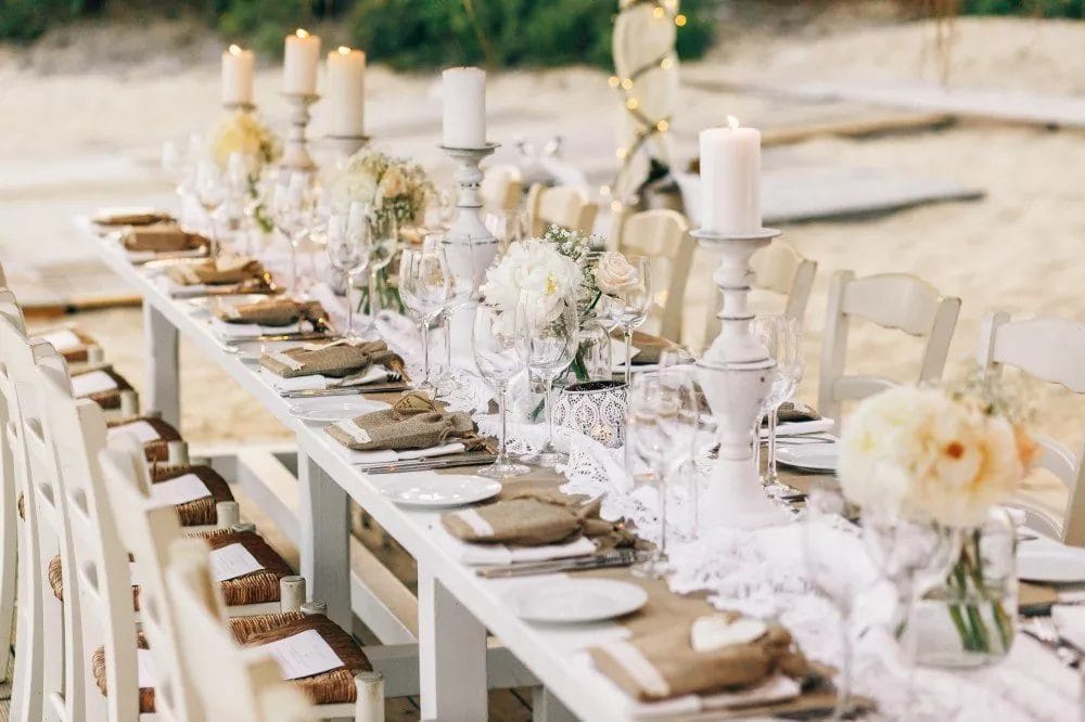 dinner table decorated with flaxen cloth white candles