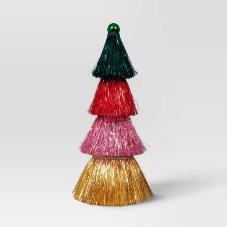 A tiered tassel tree with layers in green, red, pink, and gold colored tinsel, topped with a green colored ball.