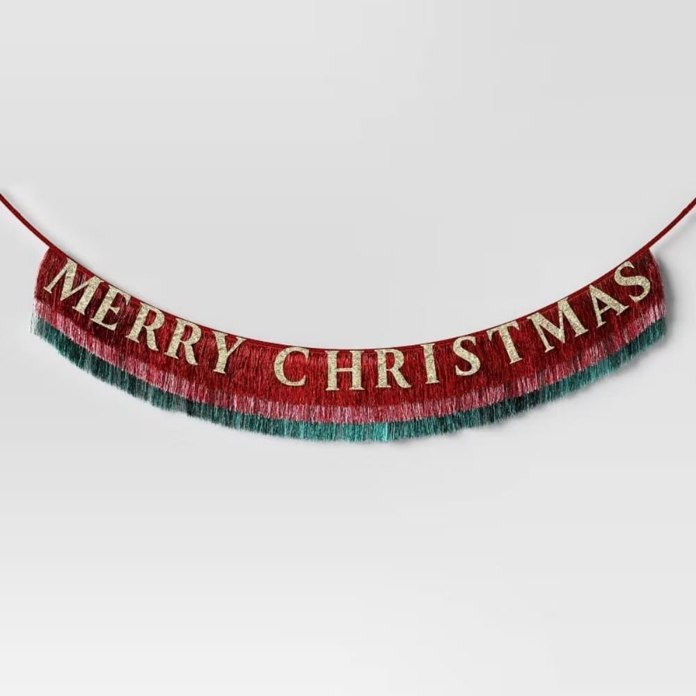 Red and green colored garland with gold colored letters spelling _MERRY CHRISTMAS._