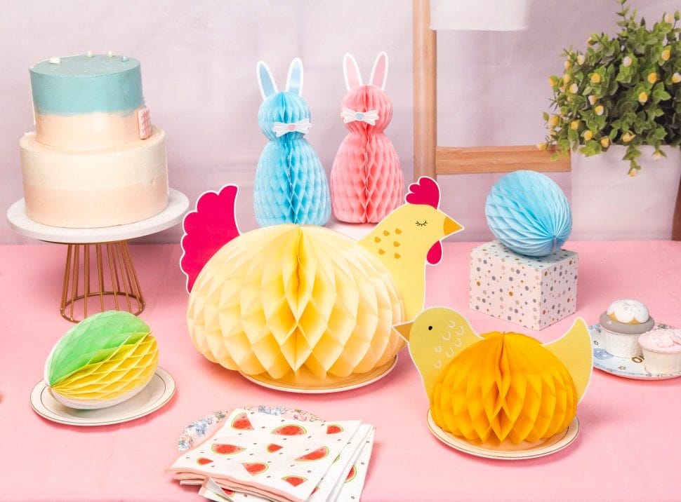 Pastel Easter table with honeycomb paper decorations and cake