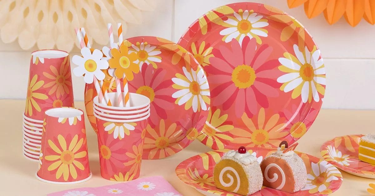 A bold, retro set with plates and cups featuring large, vibrant pink and orange daisies, evoking a 70s vibe.