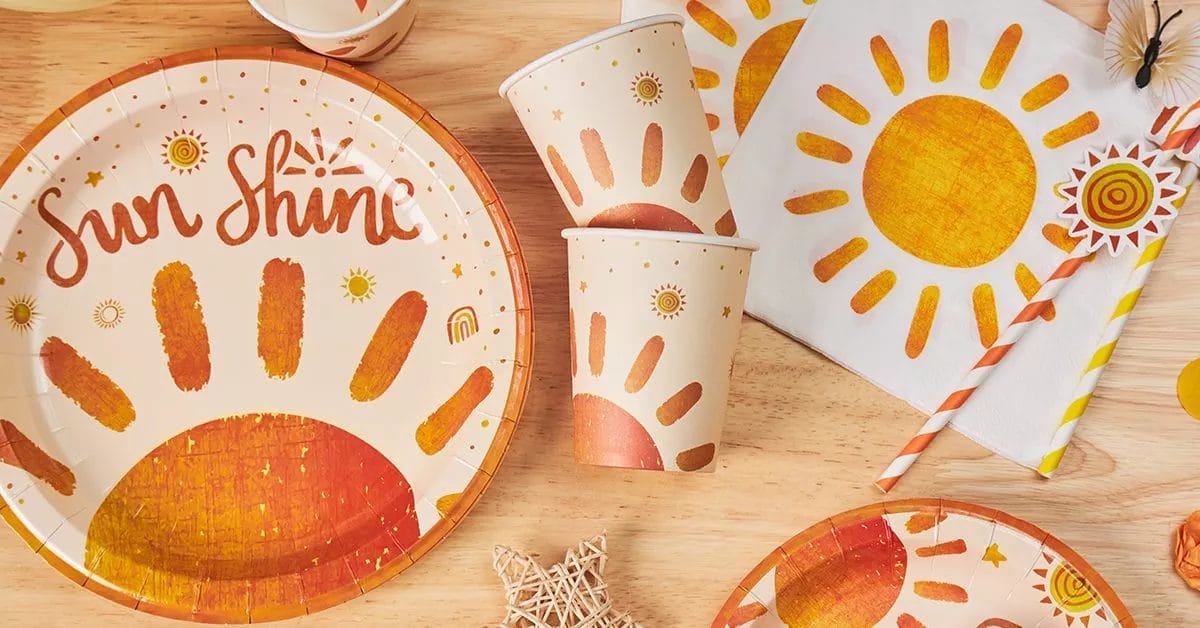 A close-up of the sunny party collection, showcasing plates, cups, and napkins with bold sun illustrations and a warm, inviting color palette