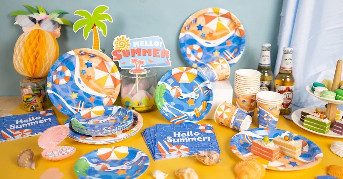 A fun, tropical arrangement with plates, cups, and napkins decorated with beach umbrellas, flip-flops, and Hello Summer! signage.