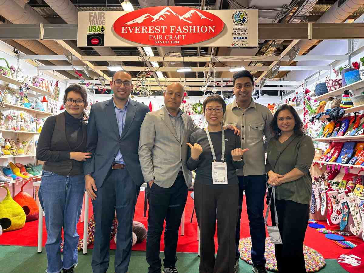 Group of six professionals posing at the Everest Fashion Fair Craft booth